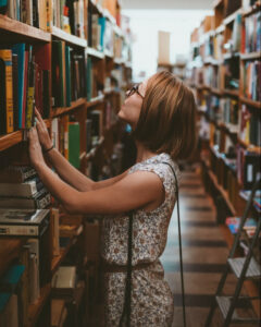 woman looking at books in library